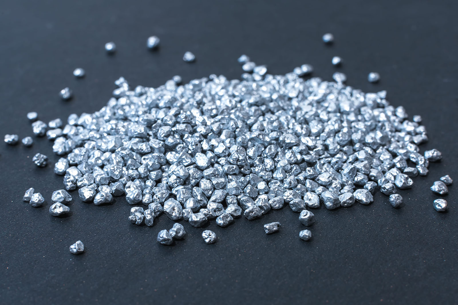 Pile of small silver pieces displayed on dark background